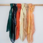 Hand-dyed silk tichel in soft yellow butter tone, draped and laid flat.