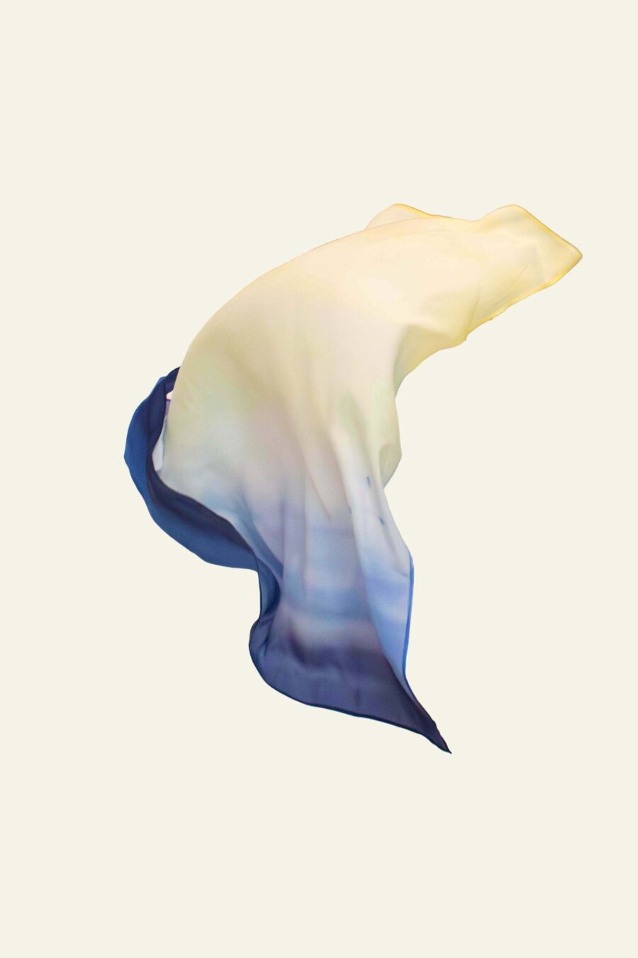 Hand-painted silk scarf in soft sky-inspired gradients of blue, green, and yellow, shown floating in the air and worn as a Jewish head covering (tichel)