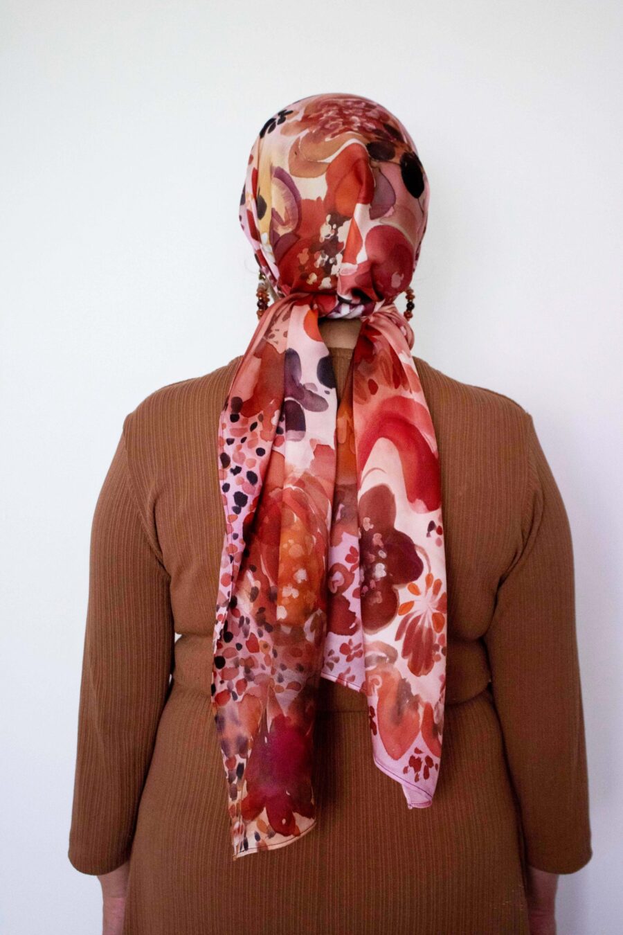 Hand-painted silk mitpachat with red, pink, and orange floral design – vibrant headscarf for Jewish women